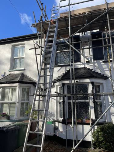 Full scaffold erected around a period property with bay windows for a roof renovation